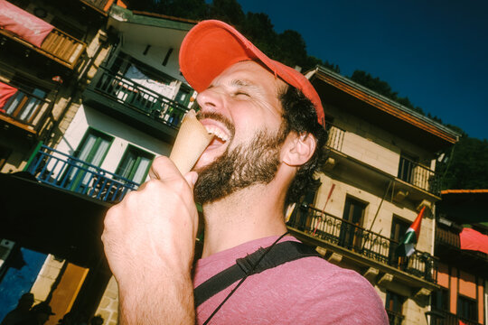 Man enjoys ice cream in a lively market during the afternoon