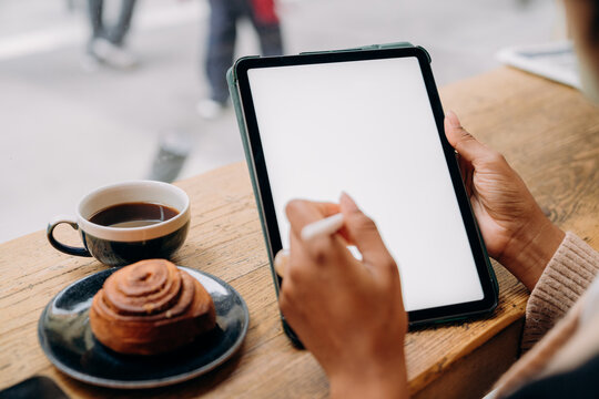 A woman using a tablet in a cafe