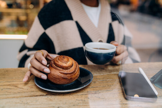 A woman eating a bun in a cafe