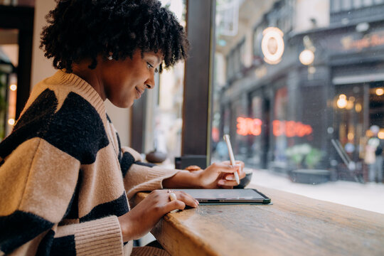 A woman using a tablet in a cafe