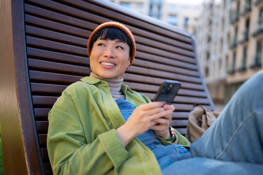 Person sits outside using a smartphone in the city