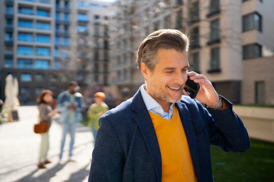 Man talking on phone in urban setting with friends