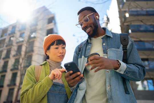 Friends talking and checking phone in the city