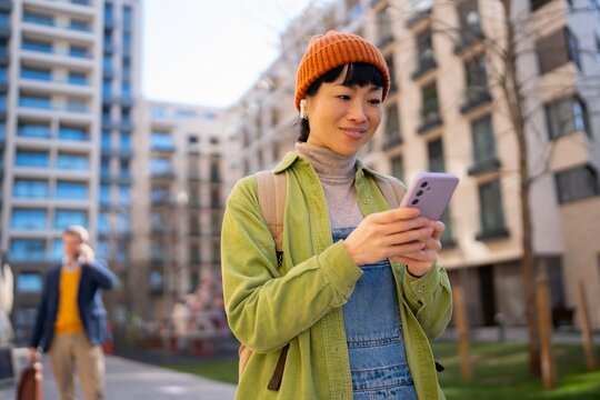 Woman using phone in urban area on sunny day