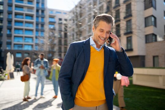 Man talking on phone in urban courtyard setting