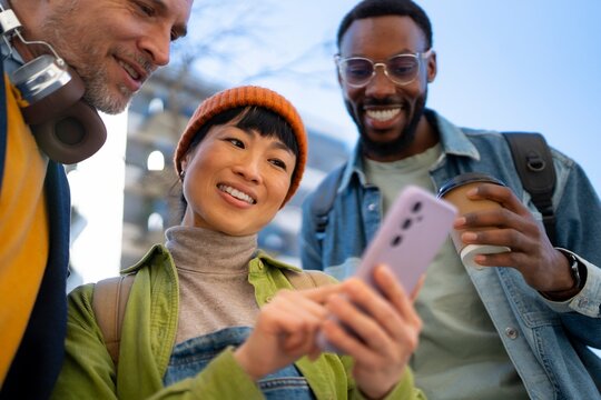 Friends laughing and looking at a phone together