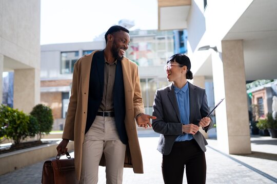 Professionals walking and talking outdoors