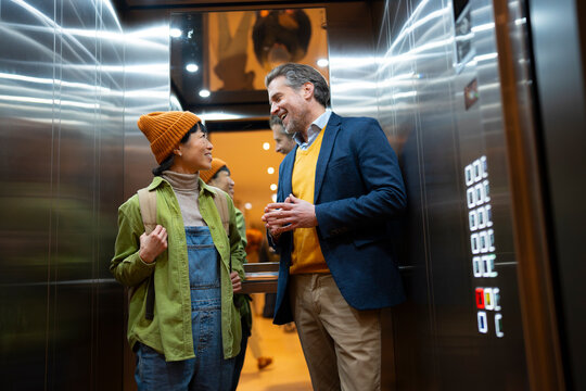 Two people talking in an elevator at a building