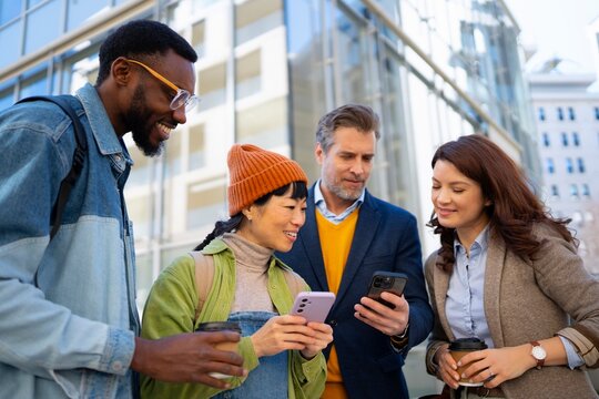Friends looking at phones in a city setting