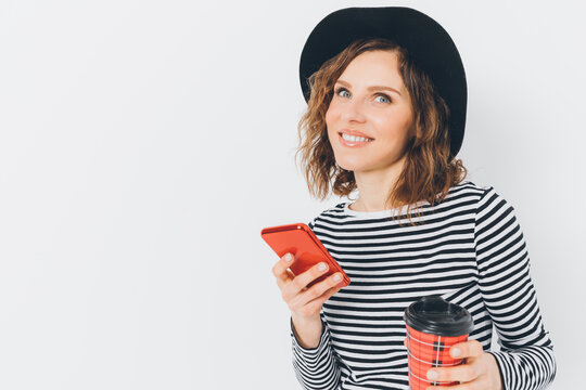 Happy young woman with curly hair, red phone, and coffee