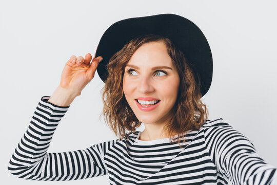 Smiling woman in black hat and striped top