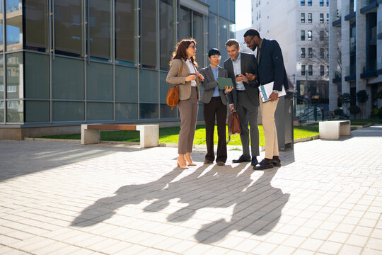 Business team discusses project in urban setting