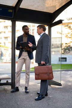 Men talking at a bus stop in the city