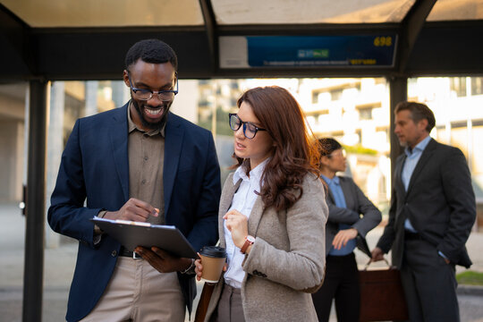 Professionals discussing ideas at a bus stop