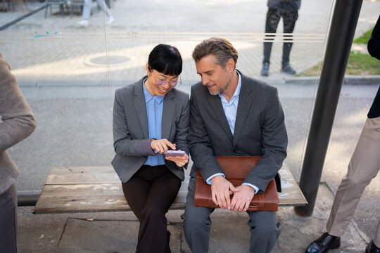Business people waiting at a bus stop in the city