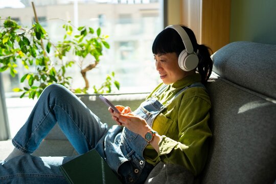 Woman listens to music while relaxing at home