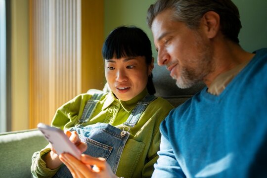 Friends share a moment while looking at a phone