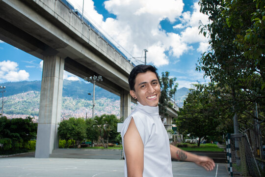 Young Person Smiles While Standing on Court Near a Railway