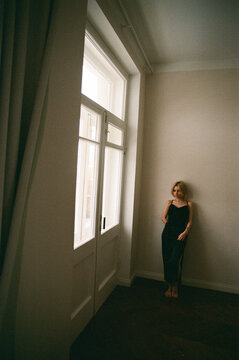 Barefoot Blonde in Black Slip Dress by Tall Window, Film Photo