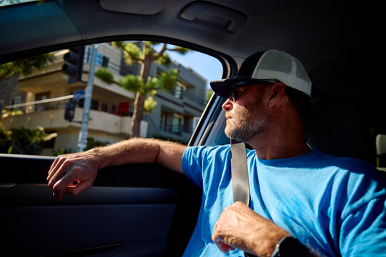 Man looks out the car window during the afternoon drive in LA