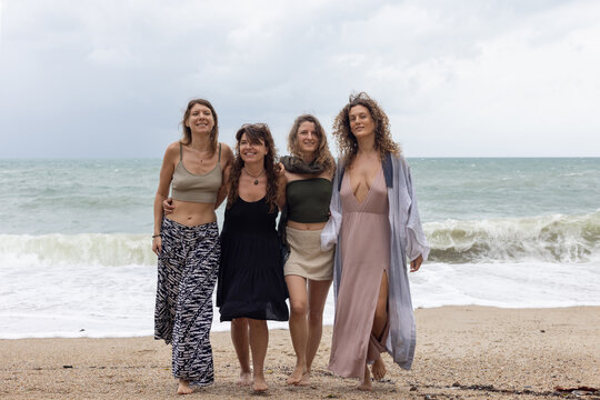friendship, group of women hug together on the beach