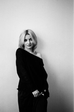 Blonde Standing Against Wall in Off-Shoulder Top, B&W Portrait
