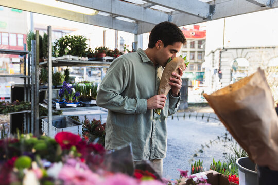 Young Man Choosing Fresh Flowers at an Outdoor Urban Flower Market