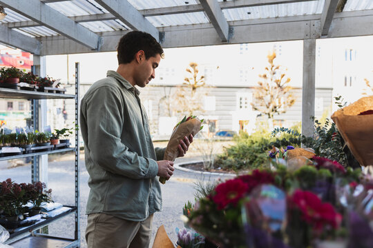 Young Man Choosing Fresh Flowers at an Outdoor Urban Flower Market