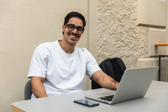 Smiling University Student Studying with Laptop in Modern Campus