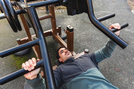 Man Performing Chest Press on Resistance Machine at Outdoor gym