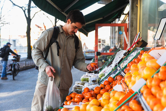 Man Buying Fresh Organic Vegetables at an Outdoor City Market