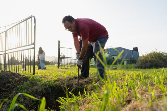 Man Digging In Rural Field