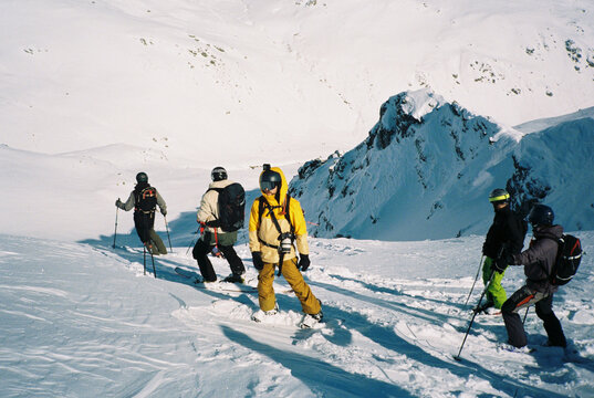 Group of skiers stand on a high mountain point