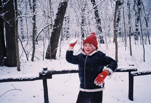 a boy in winter playing with snowballs