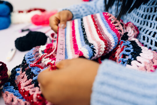 Close up of hands measuring a crotchet piece
