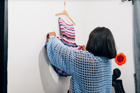 Young woman putting up her crotchet work