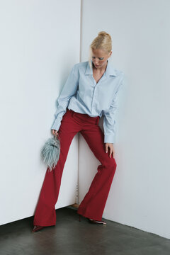 Fashion portrait woman in blue shirt posing with handbag
