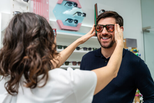 Optician Fitting Sunglasses On Customer