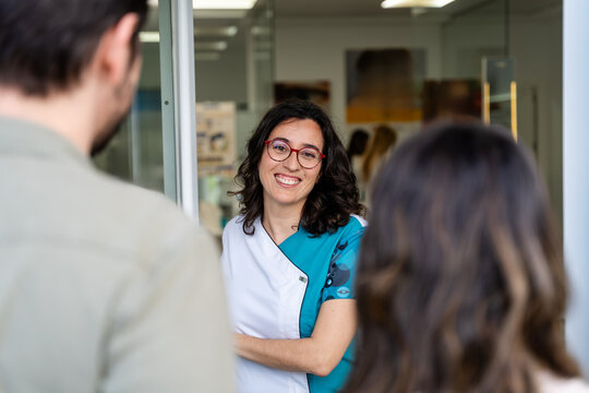 Optometrist Greeting Couple At Door