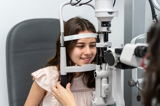 Optometrist Adjusting Slit Lamp For Teen Patient