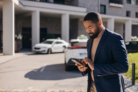 Businessman looks at his mobile phone in the city.