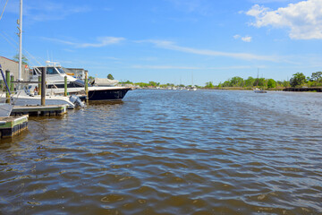 Obraz premium The Sampit River as it passes by the historic downtown waterfront Harborwalk and marina at the city of Georgetown, South Carolina.