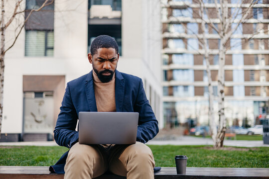 Businessman foused on his laptop outdoors
