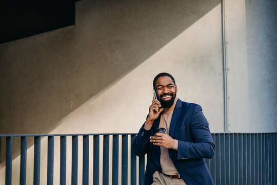 Happy man speaks on the phone outdoors