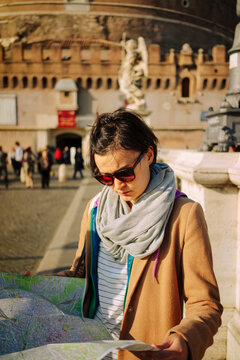 Woman looking at a map in front of Castel Sant'Angelo in Rome