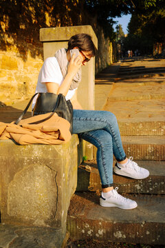 Woman talking on the phone on the steps of Piazzale Michelangelo