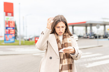 High gas prices woman reading receipt at station © Maksym