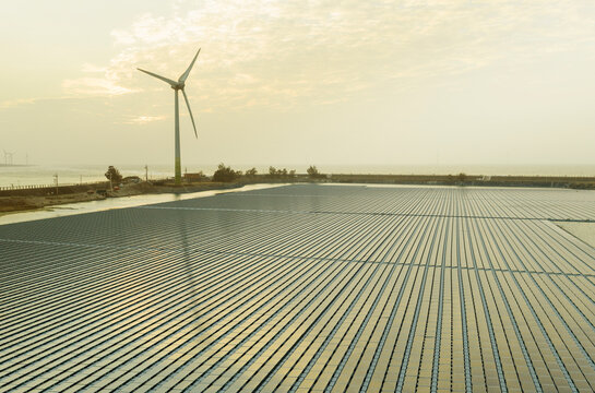 Floating Solar Panels and Wind Turbine at Sunset