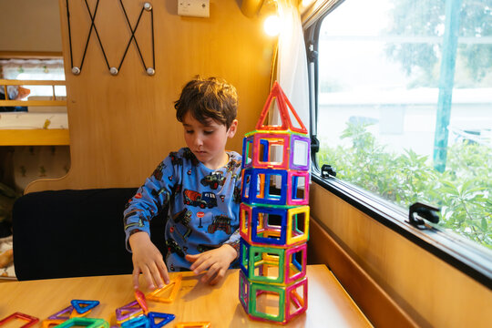 Kid playing with magnetic blocks inside a caravan