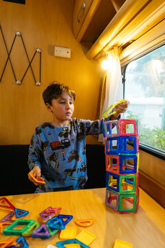 Young boy building tower with colorful magnetic tiles